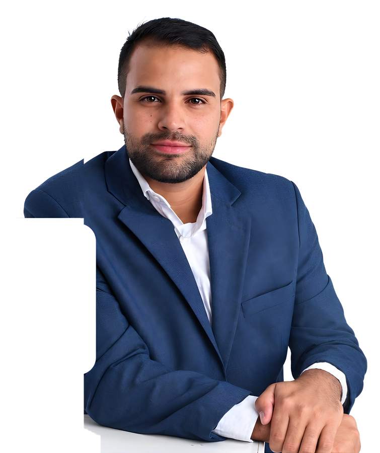 Guilherme Eduardo sentado, de blazer azul e camisa branca, com as mãos apoiadas na mesa
